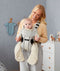 Parent holing a baby in a carrier wearing an ergoPouch Sleep Suit Sack 3.5 TOG Night Sky
