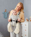 Parent holing a baby in a carrier wearing an ergoPouch Sleep Suit Sack 3.5 TOG Night Sky