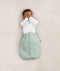 Newborn wearing a ergoPouch Butterfly Cardi Natural, for arms up sleeping and help with arms-out transition