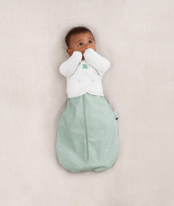 Newborn wearing a ergoPouch Butterfly Cardi Natural, for arms up sleeping and help with arms-out transition