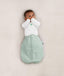 Newborn wearing a ergoPouch Butterfly Cardi Natural, for arms up sleeping and help with arms-out transition