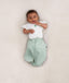 Baby wearing an ergoPouch Butterfly Cardi Natural with both arms out of swaddle
