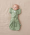 Newborn being swaddled in ergoPouch Cocoon Swaddle Sack 1.0 TOG with Butterfly Cardi for arms up sleeping, in heritage color Willow