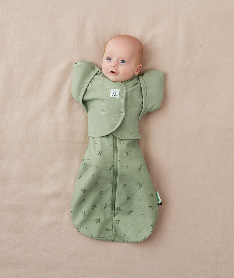 Newborn being swaddled in ergoPouch Cocoon Swaddle Sack 1.0 TOG with Butterfly Cardi for arms up sleeping, in heritage color Willow