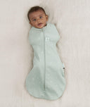 Newborn wearing an ergoPouch Cocoon Swaddle Sack 0.2 TOG Sage with arms in