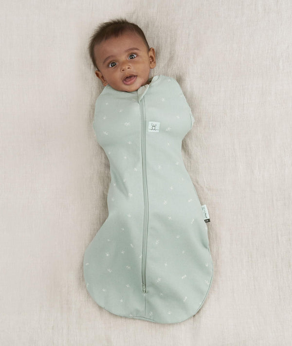 Newborn wearing an ergoPouch Cocoon Swaddle Sack 0.2 TOG Sage with arms in