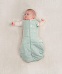 Baby being swaddled in ergoPouch Cocoon Swaddle Sack in Sage, arms out transition