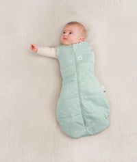 Baby being swaddled in ergoPouch Cocoon Swaddle Sack in Sage