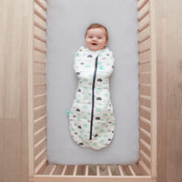 Baby lying on a crib  wearing a Cocoon Swaddle Sack 2.5 TOG with its arms in