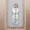 Baby lying on a crib  wearing a Cocoon Swaddle Sack 2.5 TOG with its arms in