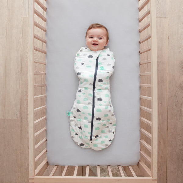 Baby lying on a crib  wearing a Cocoon Swaddle Sack 2.5 TOG with its arms in