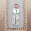 Baby lying on a crib  wearing a Cocoon Swaddle Sack 2.5 TOG with its arms in