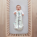 Baby lying on a crib  wearing Cocoon Swaddle Sack 2.5 TOG with its arms out