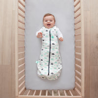 Baby lying on a crib  wearing Cocoon Swaddle Sack 2.5 TOG with its arms out
