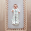 Baby lying on a crib  wearing Cocoon Swaddle Sack 2.5 TOG with its arms out