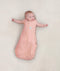 Newborn wearing ergoPouch Cocoon Swaddle Sack 0.2 TOG Berries, transitioning to arms out sleeping