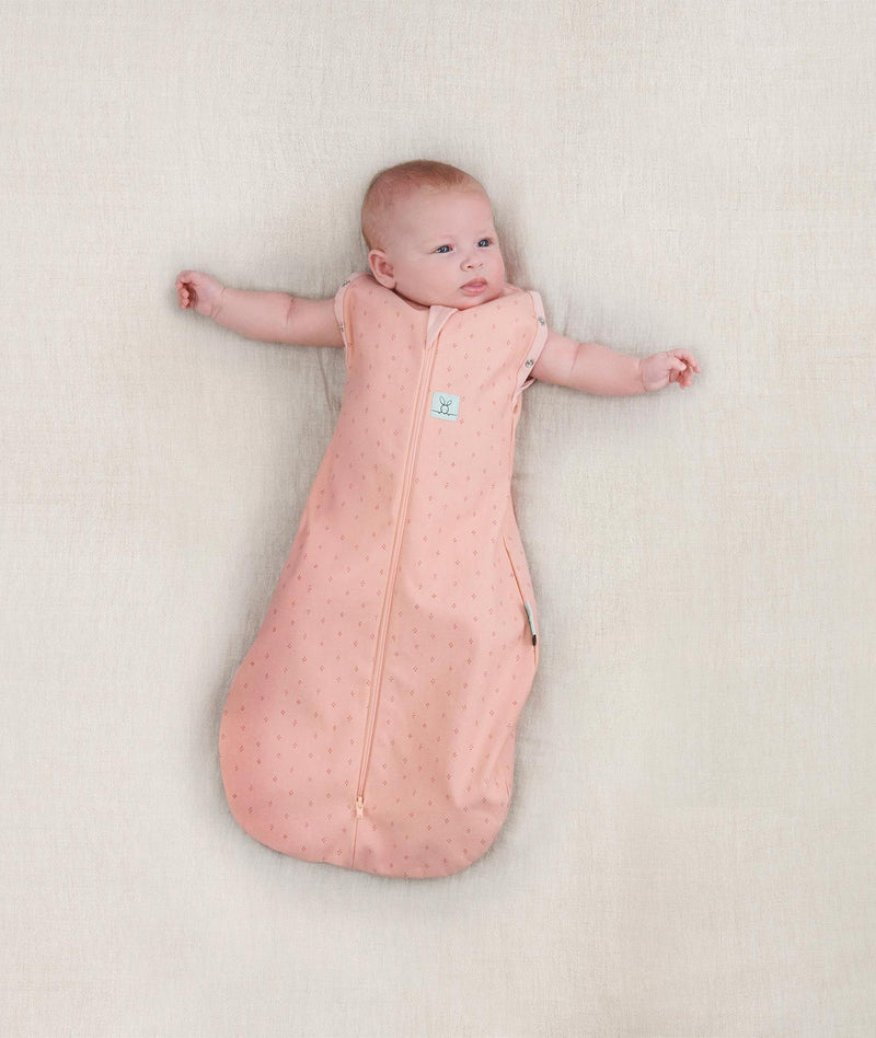 Newborn wearing ergoPouch Cocoon Swaddle Sack 1.0 TOG Berries, arms out sleeping 