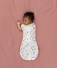 Newborn transitioning to arms-out sleeping, in an ergoPouch Cocoon Swaddle Sack 1.0 TOG Daydream