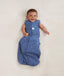 Newborn wearing ergoPouch Cocoon Swaddle Sack 0.2 TOG Night Sky, transitioning to arms out sleeping