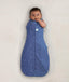 Newborn wearing ergoPouch Cocoon Swaddle Sack 0.2 TOG Night Sky, transitioning to arms out sleeping
