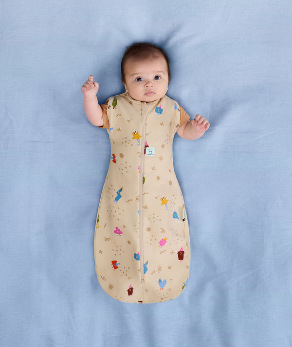 Baby sleeping with arms out in a ergoPouch Cocoon Swaddle Sack 1.0 TOG Birthday Blobs