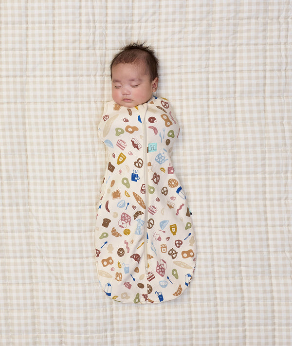 Newborn baby asleep wearing ergoPouch Cocoon Swaddle Sack 0.2 TOG in Bon Appetit
