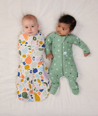 Two lying sitting in ergoPouch Long Sleeve Romper 1.0 TOG Sweet Orchard and Cocoon Swaddle Sack 1.0 TOG Fruit Salad