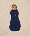 Baby snuggled in ergoPouch Cocoon Swaddle Sack with its arms in.