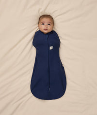 Baby snuggled in ergoPouch Cocoon Swaddle Sack with its arms in.