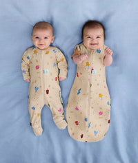 Smiling newborns ergoPouch Long Sleeve Romper 1.0 TOG Birthday Blobs and Long Sleeve Romper 0.2 TOG Birthday Blob, transitioning arms out sleeping