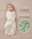 Baby lying on a beige surface wrapped in a Cocoon Swaddle Sack with text highlighting organic cotton fabric and two-way zipper and a close-up inset of the dual zippers. 