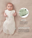 Baby lying on a beige fabric in an oatmeal-colored swaddle sack with arms out, featuring callout text highlighting armhole poppers and a bell-shaped design.