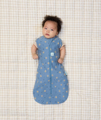 Newborn baby wearing ergoPouch Cocoon Swaddle Sack 1.0 TOG in Petite Pretzel with their arms out