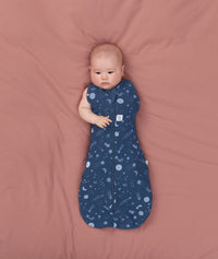 Baby transitioning to arms out sleeping easily with the ergoPouch Cocoon Swaddle Sack 1.0 TOG Starbeam