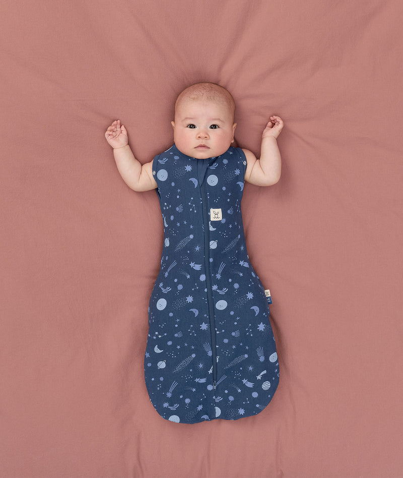 Baby transitioned to arms out sleeping easily with the ergoPouch Cocoon Swaddle Sack 1.0 TOG Starbeam
