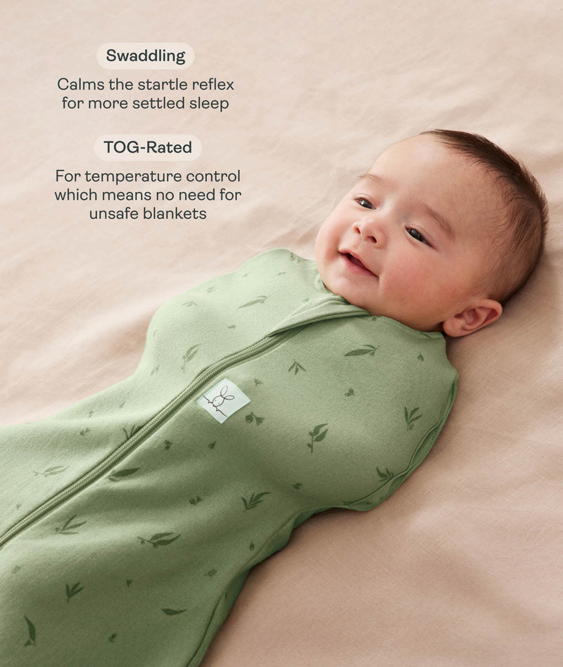 Baby being swaddled in a green Cocoon Swaddle Sack lying on a beige surface with text highlighting swaddling benefit and TOG rating feature.