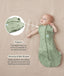 Baby lying on a beige surface in a green patterned swaddle sack with arms out, featuring callout text highlighting armhole poppers and a bell-shaped design.