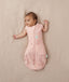 Newborn wearing ergoPouch Cocoon Swaddle Sack 0.2 TOG Daisies, transitioning to arms out sleeping