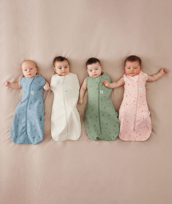 Baby sleeping with arms out in a ergoPouch Summer Cocoon Swaddle Sack Bundle