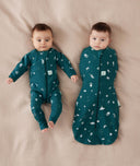 Two newborns wearing ergoPouch Cocoon Swaddle Sack 0.2 TOG and Long Sleeve Romper in Ocean Blue