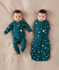 Two newborns wearing ergoPouch Cocoon Swaddle Sack 0.2 TOG and Long Sleeve Romper in Ocean Blue