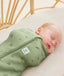Baby wearing an ergoPouch Cocoon Swaddle Sack 0.2 TOG Willow in a bassinet