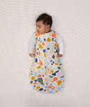 Baby sleeping with arms out in a ergoPouch Cocoon Swaddle Sack 2.5 TOG Fruit Salad