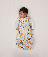 Baby sleeping with arms out in a ergoPouch Cocoon Swaddle Sack 2.5 TOG Fruit Salad