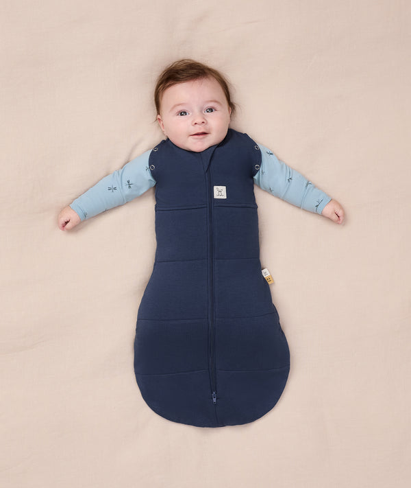 Baby wearing an ergoPouch Cocoon Swaddle Sack 2.5 TOG with its two arms out.