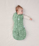 Newborn wearing ergoPouch Cocoon Swaddle Sack 2.5 TOG Sweet Orchard, transitioning to arms out sleeping