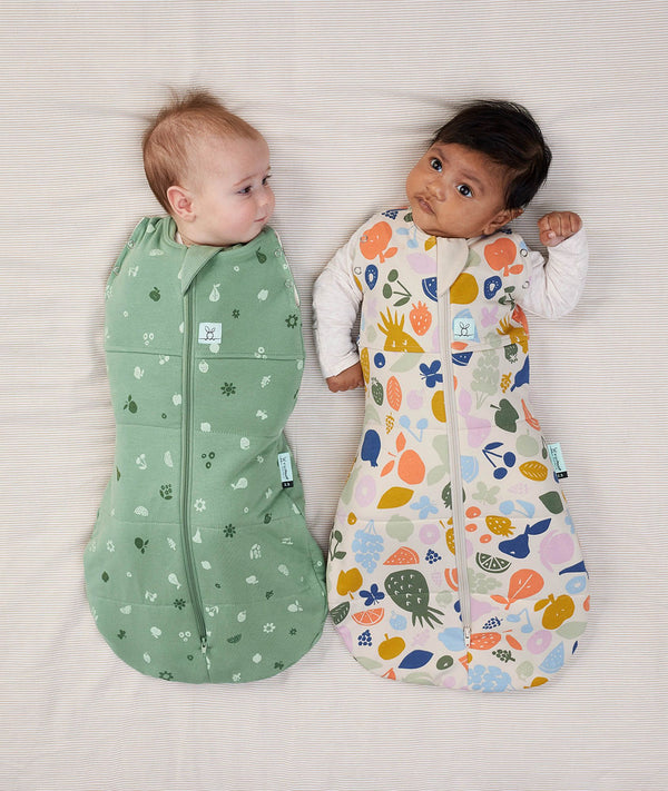 Two babies swaddled in ergoPouch Cocoon Swaddle Sack 2.5 TOG Sweet Orchard and Fruit Salad, warm for the winter