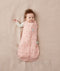 Baby wearing a ergoPouch Cocoon Swaddle Sack 3.5 TOG Daisies, transitioning to arms out sleeping