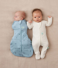 Two babies asleep in ergoPouch Cocoon Swaddle Sack 2.5 TOG Dragonflies and Long Sleeve Romper