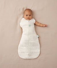 Baby wearing a ergoPouch Cocoon Swaddle Sack 2.5 TOG Oatmeal Marle, transitioning to arms out sleeping